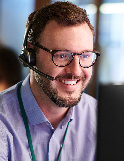 Customer service representative with a headset and working at a computer